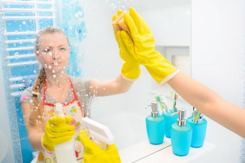 Cleaner applying safety procedures with protective gear and warning sign